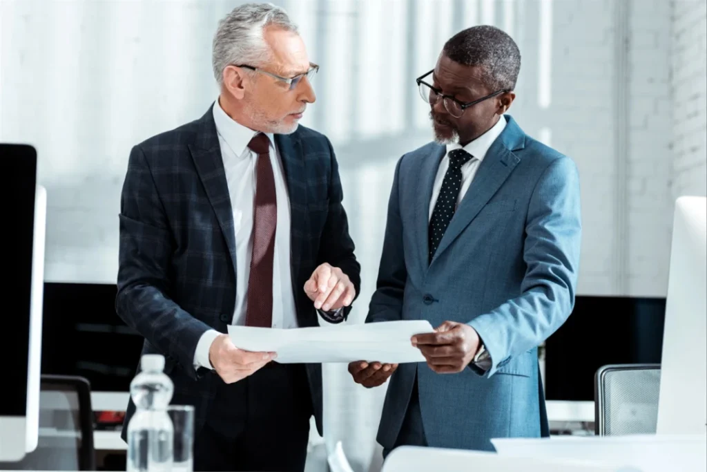 two business partners holding and discussing a document